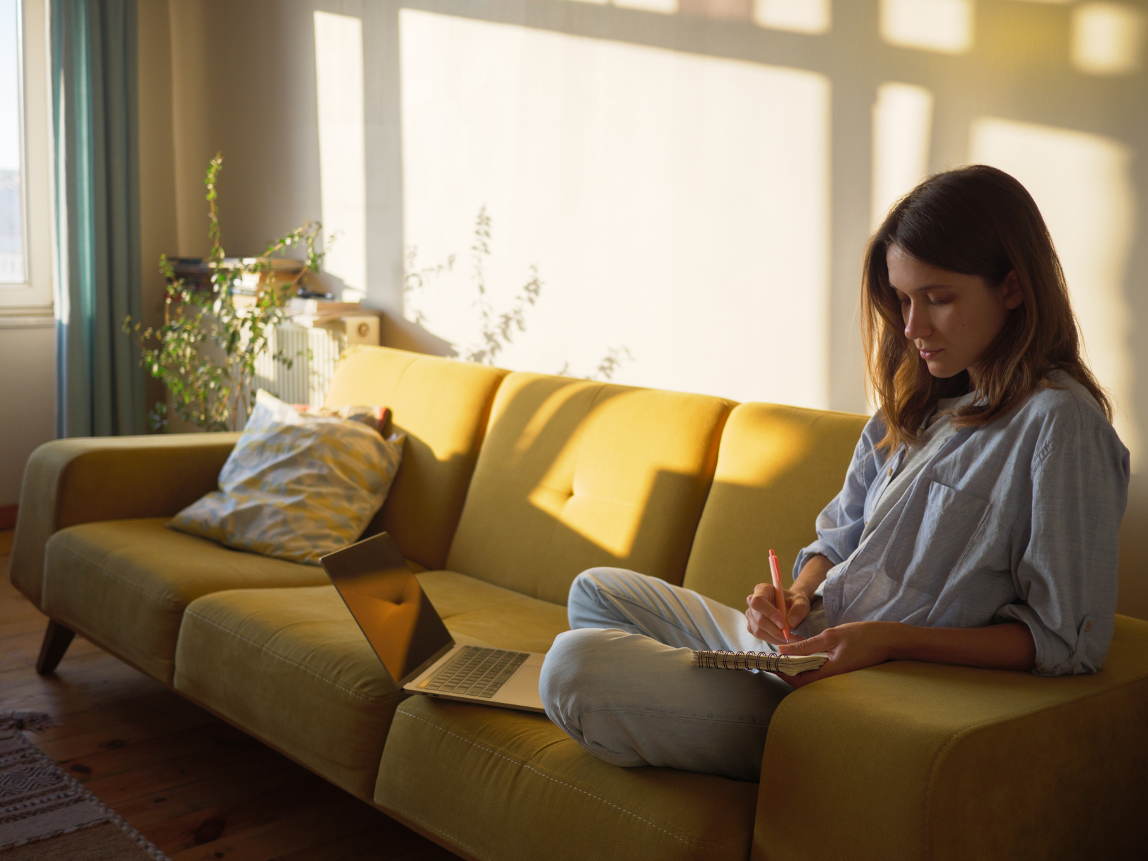 Woman relaxing on couch in warm sunlight